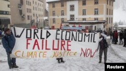 Climate activists display a banner during a protest ahead of the World Economic Forum (WEF) 2023 in the Alpine resort of Davos, Switzerland, Jan. 5, 2023. 