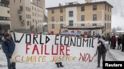 Aktivis iklim memasang spanduk berisi protes mengenai seruan "Keadilan Iklim" menjelang Forum Ekonomi Dunia (WEF) 2023 di resor pegunungan Alpen di kota Davos, Swiss (foto: dok).