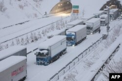 Truk terlihat terjebak akibat salju tebal di Jalan Tol Shin-Meishin di Yokkaichi, Prefektur Mie, 25 Januari 2023. (JIJI PRESS / AFP)