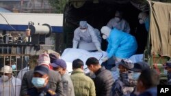 Medical personnel load the body of a victim onto a truck to be transported to Kathmandu, in Pokhara, Nepal, Jan 17, 2023.