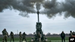 资料照片：2023年1月9日，乌克兰士兵在乌克兰赫尔松地区用美国提供的M777榴弹炮向俄罗斯阵地开火。(美联社照片)
