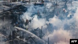 Firefighters try to extinguish a fire at the Guryong village, one of South Korea's last remaining slums, in southern Seoul.