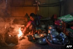 FILE - Former devadasi Vatsala Kuttal cooks at her home in Jalalpur village of Belgaum district, in India's Karnataka state, Sept. 21, 2022.