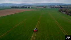 FILE - A farmer fertilizes a field on the outskirts of Frankfurt, Germany, April 4, 2022. Russia's war in Ukraine pushed up fertilizer prices but they have come down since their peak in mid-2022.