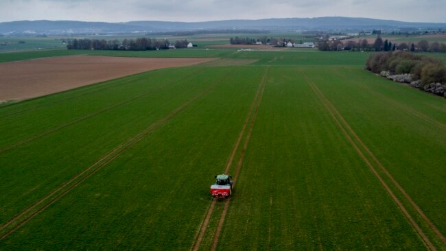 FILE - A farmer fertilizes a field on the outskirts of Frankfurt, Germany, April 4, 2022. Russia's war in Ukraine pushed up fertilizer prices but they have come down since their peak in mid-2022.