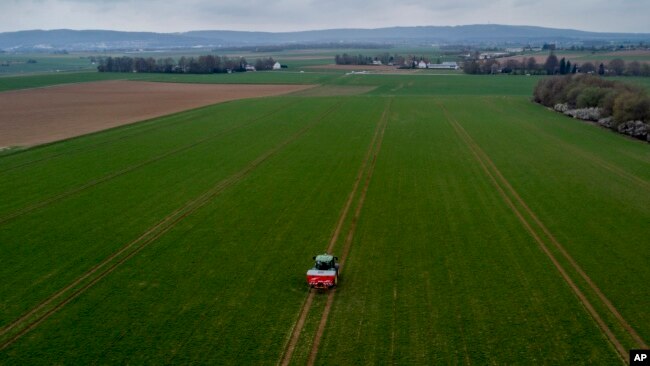 FILE - A farmer fertilizes a field on the outskirts of Frankfurt, Germany, April 4, 2022. Russia's war in Ukraine pushed up fertilizer prices but they have come down since their peak in mid-2022.
