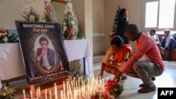 FILE: Mourners lay candles at Radio Amplitude FM where a portrait of journalist Martinez Zogo has been placed to pay tribute to him, in Yaounde on January 23, 2023. in what a rights group media called a kidnapping was found dead, his employer and police said on January 22, 2023.