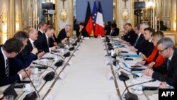 Delegasi Prancis yang dipimpin Presiden Prancis Emmanuel Macron (kanan) dan delegasi Jerman di bawah Kanselir Jerman Olaf Scholz (kiri) menghadiri rapat kerja bilateral di Istana Elysee di Paris, Minggu 22 Januari 2023.