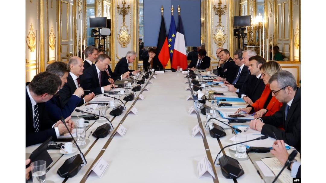 France's President Emmanuel Macron (R) and German Chancellor Olaf Scholz (L) attend a working session at the Elysee Palace in Paris, Jan. 22, 2023.