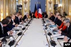 France's President Emmanuel Macron (R) and German Chancellor Olaf Scholz (L) attend a working session at the Elysee Palace in Paris, Jan. 22, 2023.