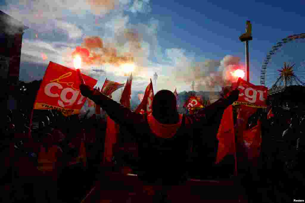 Protesters hold CGT labour union flags and flares during a demonstration against the French government's pension reform plan in Nice, as part of a day of national strike and protests in France.