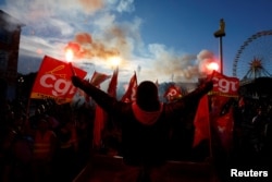 FILE - Protesters hold CGT labour union flags and flares during a demonstration against the French government's pension reform plan in Nice, as part of a day of national strike and protests in France.