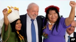 FILE - New Minister of Indigenous Peoples Sonia Guajajara, left, Brazil's President Luiz Inacio Lula da Silva, center, and new President of the National Foundation of the Indian Joenia Wapichana, celebrate during their inauguration, in Brasilia, Brazil, Jan. 11, 2023.