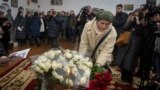 People lay flowers to honor foreign volunteers Chris Parry and Andrew Bagshaw, killed in Ukraine's war-hit east, during a memorial service at St. Sophia Cathedral in Kyiv, Ukraine, Jan. 29, 2023.