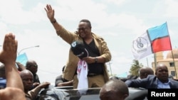 Tanzanian opposition leader Tundu Lissu waves to supporters after he returns from exile, as his vehicle moves through the streets of Dar es Salaam, Tanzania, Jan. 25, 2023. 