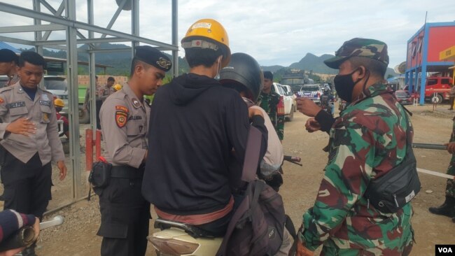 Personel TNI-POLRI melakukan pemeriksaan terhadap pekerja yang hendak memasuki pabrik smelter PT GNI di Morowali Utara, Sulawesi Tengah, 19 Januari 2023 (Foto : VOA/Yoanes Litha)