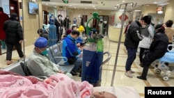 FILE - A patient lies on a bed at the emergency department of a hospital during the COVID-19 outbreak in Shanghai, China, Jan. 17, 2023. Some say China's zero-COVID policy widened the gap in the rural health system.