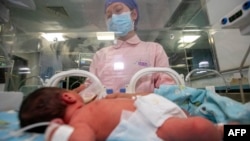 FILE - A nurse takes care of a newborn baby at a hospital in Taizhou in China's eastern Zhejiang province on May 12, 2022.