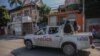 Policías armados recorren las calles de Puerto Príncipe, la capital haitiana, tras el llamado a una huelga general lanzada por varias asociaciones profesionales y empresas para denunciar la inseguridad en el país, el 18 de octubre. 2021.