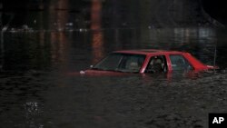 FILE - An empty vehicle is surrounded by floodwaters on a road in Oakland, Calif., Jan. 4, 2023.