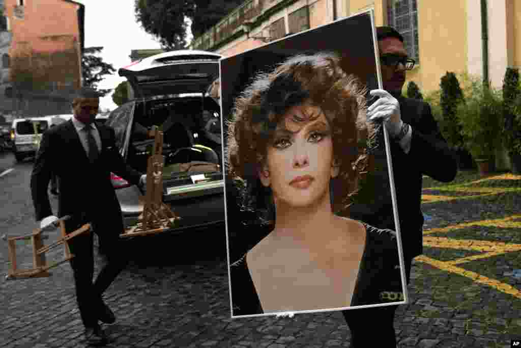 A funeral service employee carries a photo of late Italian film legend Gina Lollobrigida before her laying in state at Rome&#39;s Capitol Hill. Lollobrigida, who achieved international stardom during the 1950s and was dubbed &quot;the most beautiful woman in the world&quot; after the title of one of her movies, died in Rome on Jan. 16, 2023. She was 95.