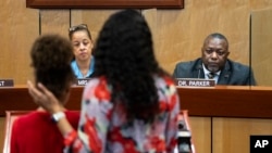  Djifa Lee, a second-grade teacher at Saunders Elementary, center, stands with her daughter as she speaks in front of the Newport News School Board at the Newport News Public Schools Administration building on Jan. 17, 2023. (Billy Schuerman/The Virginian-Pilot via AP, File)