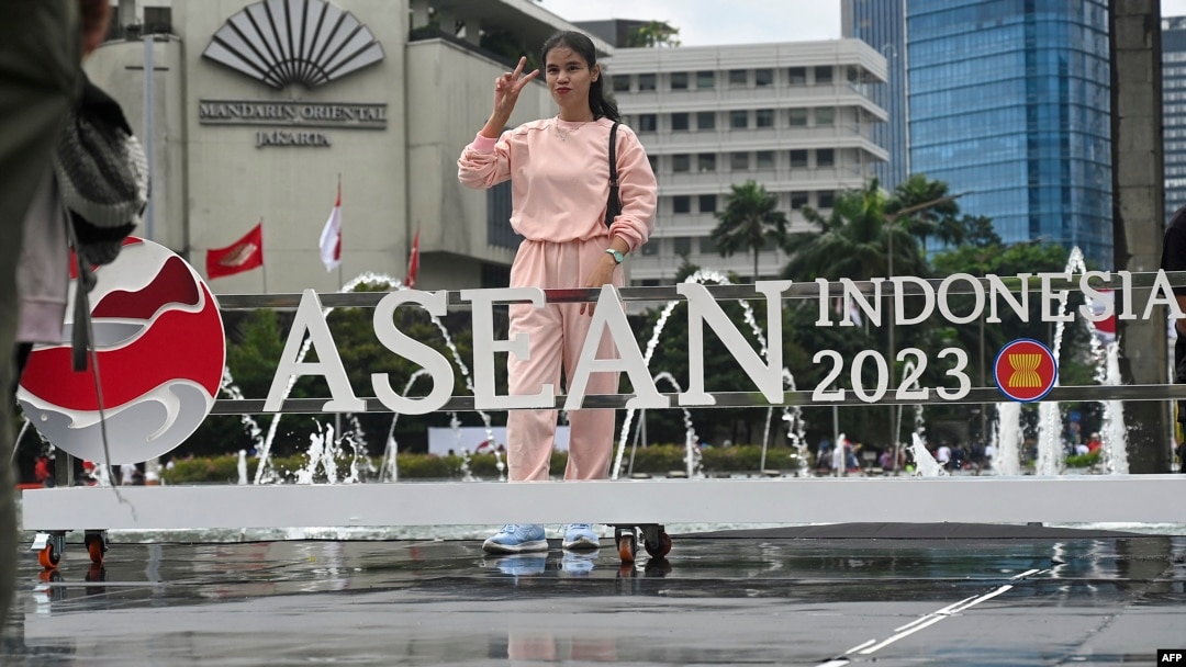Seorang perempuan berpose di logo ASEAN yang menunjukkan kepemimpinan Indonesia yang baru dipasang, setelah acara peresmian keketuaan Indonesia di Jakarta, 29 Januari 2023.