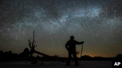 FILE - In this file photo, Dave Cooke observes the Milky Way in Ontario, Canada, early Sunday, March 21, 2021. (Fred Thornhill/The Canadian Press via AP)