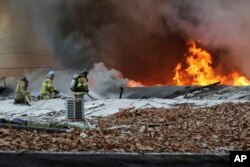 Petugas pemadam kebakaran berupaya memadamkan kobaran api di desa Guryong di Seoul, Korea Selatan, Jumat, 20 Januari 2023. (Baek Dong-hyun/Newsis via AP)