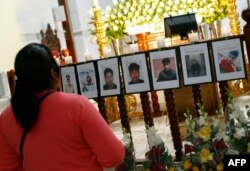 A woman looks at pictures of people killed in protests against President Dina Boluarte, during a memorial at the San Juan Catholic church in Puno, Peru, Jan. 15, 2023.