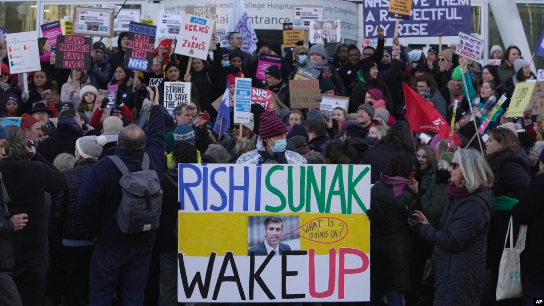 Perawat memegang spanduk saat melakukan pemogokan di luar Royal College of Nursing, di London, Rabu, 18 Januari 2023. (Foto: AP)