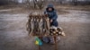 Serhi Zamulenko sells fish on the side of the road, despite shells frequently falling in the area, in Chasiv Yar, Ukraine, Jan. 22, 2023. (Yan Boechat/VOA)