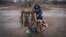Serhi Zamulenko sells fish on the side of the road, despite shells frequently falling in the area, in Chasiv Yar, Ukraine, Jan. 22, 2023. (Yan Boechat/VOA)