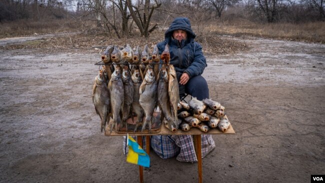 Serhi Zamulenko vende pescado al costado de la carretera, a pesar de que con frecuencia caen proyectiles en el área, en Chasiv Yar, Ucrania, el 22 de enero de 2023. (Yan Boechat/VOA)