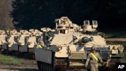 FILE - A U.S. soldier walks near Abrams battle tanks near Vilnius, Lithuania, Oct. 21, 2019.