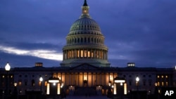FILE - The cupola of the Capitol Dome is illuminated, indicating that work continues in Washington, Oct. 6, 2021. 