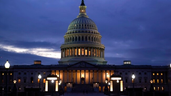 FILE - The cupola of the Capitol Dome is illuminated, indicating that work continues in Washington, Oct. 6, 2021.