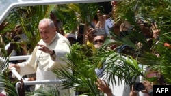 FILE - Pope Francis waves as he arrives prior to leading a mass at the Monument of Mary Queen of Peace, Port Louis, Mauritius, on Sept. 9, 2019.
