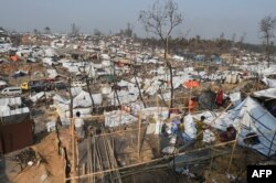 FILE - Rohingya refugee men build a temporary shelter days after a fire burnt their home at a refugee camp in Ukhia, in the southeastern Cox's Bazar district, March 25, 2021.