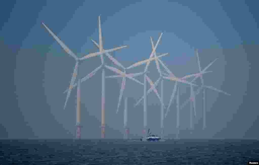 A survey vessel sails past wind turbines at the Burbo Bank offshore wind farm near New Brighton, Britain, Jan. 23, 2023.