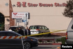 Law enforcement members gather outside the location of a shooting that took place during a Chinese Lunar New Year celebration, in Monterey Park, Jan. 22, 2023.