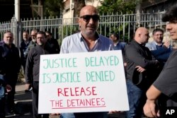 Aksi protes kerabat tahanan yang masih dalam tahap investigasi atas kasus ledakan di pelabuhan Beirut 4 Agustus 2020 di depan Istana Kehakiman di Beirut, Lebanon, 19 Januari 2023. (AP/Bilal Husein)