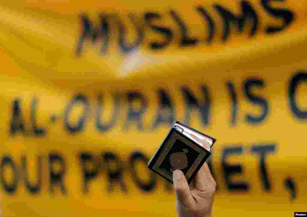 A man holds a copy of the Koran during a protest in front of the Swedish embassy in Kuala Lumpur, Malaysia, after Rasmus Paludan, leader of Danish far-right political party Hard Line, burned a copy of the Koran near the Turkish Embassy in Stockholm.