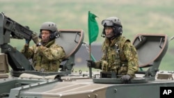 ARCHIVO - Soldados de las Fuerzas Terrestres de Autodefensa de Japón montan un obús autopropulsado durante un ejercicio con fuego real en los campos de entrenamiento en el Área de Maniobras del Este de Fuji en Gotemba, al suroeste de Tokio, el 22 de mayo de 2021.