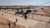 FILE - Iraqi security forces and vehicles are seen at the border crossing between the Iraqi town of Qaim and Syria's Boukamal, in Qaim, Iraq, Sept. 30, 2019. Drones reportedly attacked a convoy in the region Sunday.