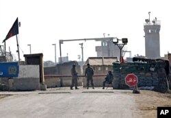 FILE - Afghan National Army (ANA) soldiers stand guard at the main gate of the Parwan Detention Facility Center on the outskirts of Bagram, some 50 kilometers (30 miles) north of Kabul, Feb. 13, 2014.