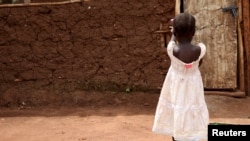 FILE - A 3-year-old who was offered for adoption without her family's knowledge plays in Uganda, April 14, 2015. Norway has tightened controls over adoptions from abroad but will allow them to continue as it investigates the legality and ethics of past adoptions.