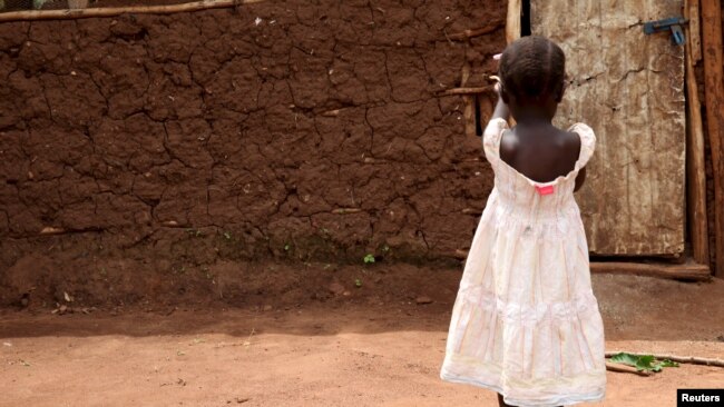 FILE - A 3-year-old girl who was offered for adoption without her family's knowledge walks at her grandmother's home in rural Uganda, April 14, 2015. Ugandan journalist Solomon Serwanjja worked to expose an illegal adoption racket in Uganda for NTV Uganda in 2013.