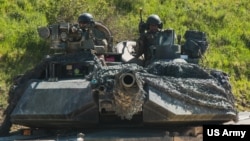 FILE - U.S. soldiers in an M1 Abrams tank conduct vehicle movements as part of an exercise at the Hohenfels Training Area, Germany, June 2, 2022.