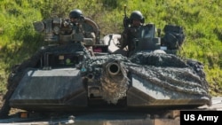 FILE - U.S. soldiers in an M1 Abrams tank conduct vehicle movements as part of an exercise at the Hohenfels Training Area, Germany, June 2, 2022.